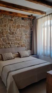 ein großes Bett in einem Zimmer mit Ziegelwand in der Unterkunft Il Busciolotto in Santa Teresa Gallura