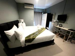 a bedroom with a bed and a table and a kitchen at Kangaroo Residence Udonthani in Udon Thani