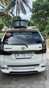 a white car with a sign on the back at Nanda Homestay in Kuta Lombok