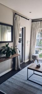 uma sala de estar com uma mesa e uma janela em Cottage in Sandton em Joanesburgo