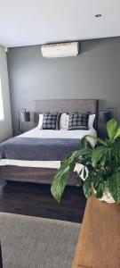 a bedroom with a large bed and a plant at Cottage in Sandton in Johannesburg