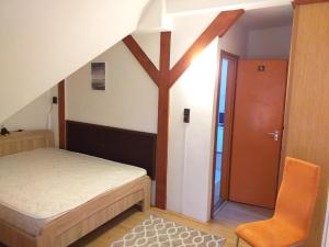 1 dormitorio pequeño con 1 cama y 1 silla en Balatonszemesi Nyaralóház, en Balatonszemes