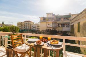 a table with two plates of food on a balcony at Luxury Ap.Tennis in Ágios Rókkos