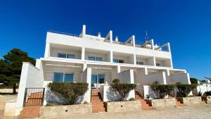 a white building with trees in front of it at Duplex Ancla in L'Ametlla de Mar
