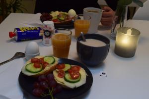 a table with a plate of food with fruit and drinks at Göteborgs Bed & Breakfast in Gothenburg