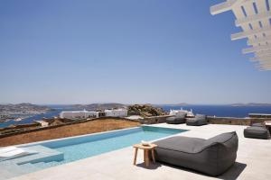 a villa with a pool with a couch and a view at Annez Villa with Private Pool Panoramic Sea View in Mikonos