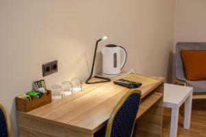 a wooden desk with a lamp and glasses on it at Veldzes Nams in Ventspils