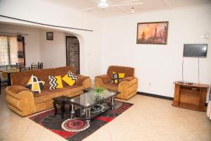 ein Wohnzimmer mit 2 Sofas und einem Tisch in der Unterkunft KANAMAI PRIME VILLAS in Mombasa