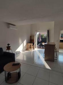 sala de estar con sofá y mesa en Au soleil, marcher vers la plage en Torreilles