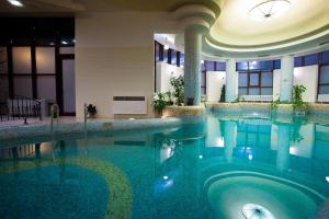 a large swimming pool in a hotel lobby at Denisa Boutique in Poiana Brasov