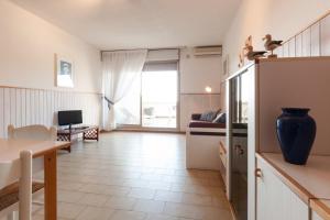 a kitchen and living room with a table and a couch at Etruria Residence in San Vincenzo