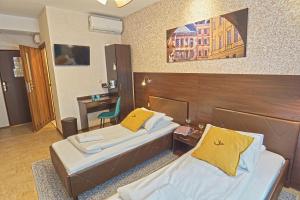 ルブリンにあるNoclegi Orla 6のベッド2台とデスクが備わるホテルルームです。