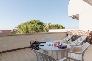 un tavolo bianco e sedie sul balcone di Etruria Residence a San Vincenzo