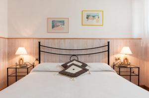 una camera con un grande letto con due lampade di Etruria Residence a San Vincenzo