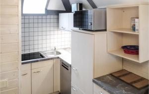 uma pequena cozinha com um lavatório e um micro-ondas em Ferienhaus 54 In Kirchheim em Kemmerode