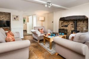 uma sala de estar com sofás e uma lareira em Honey Cottage em Stow on the Wold