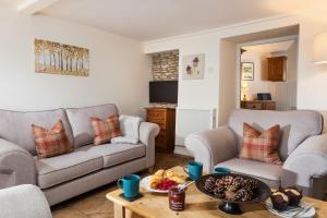 uma sala de estar com dois sofás e uma mesa em Honey Cottage em Stow on the Wold