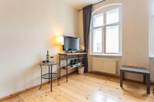 a living room with a television and a window at Zentrale Altbauwohnung im Helmholtzkiez in Berlin