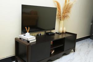 a black entertainment center with a flat screen tv at Igwe Homes - Kisaasi in Kampala