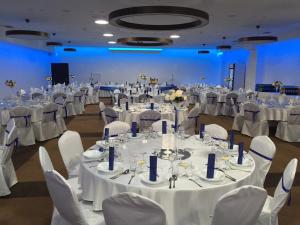 un salón de banquetes con mesas blancas y sillas blancas en Hotel Lineas, en Prešov