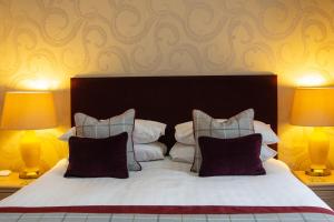 a bedroom with a large bed with two lamps at Eskdale Hotel in Langholm