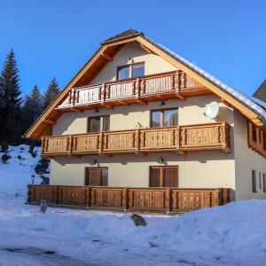 a house with a wooden deck in the snow at Apartmán Linda Tále in Tale