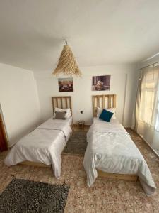 タガズートにあるSable beach surf camp taghazoutのベッドルーム1室(ベッド2台、窓付)