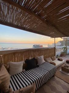 a couch sitting on a balcony with a view of the ocean at Sable beach surf camp taghazout in Taghazout