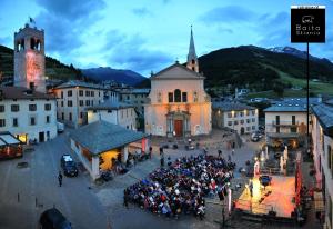 un folto gruppo di persone in piedi davanti a un edificio di Baita Skianta 3 a Bormio