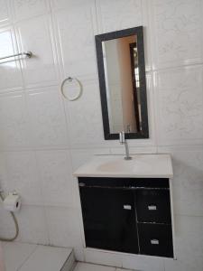 La salle de bains est pourvue d'un lavabo et d'un miroir. dans l'établissement Pousada Cor e Arte - Pelourinho, à Salvador