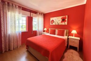 ein rotes Schlafzimmer mit einem Bett und einem Fenster in der Unterkunft Vila Caravela - Private Pool by HD Properties in Vilamoura