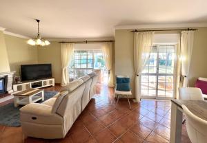 uma sala de estar com um sofá e uma televisão em Vila Caravela - Private Pool by HD Properties em Vilamoura