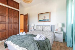 um quarto com uma cama com toalhas em Quiet Spacious House - Swimming Pool em Benagil