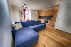 ein Wohnzimmer mit einem blauen Sofa und einer Küche in der Unterkunft Baita Skianta 3 in Bormio