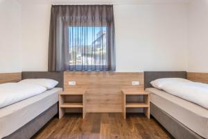 two beds in a room with a window at Aster Moments Apt Marie in San Genesio Atesino