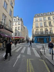 een groep mensen die een straat oversteken in een stad bij APPARTEMENT PARIS - LOUVRE & RIVOLI in Parijs
