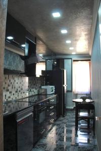 a kitchen with a refrigerator and a table in it at Rent House in Yerevan