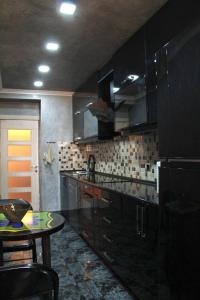 a kitchen with black cabinets and a table in it at Rent House in Yerevan