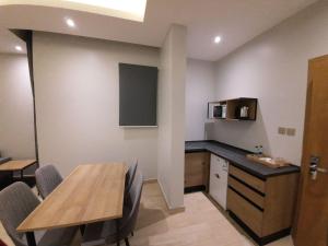 a dining room with a table and a kitchen with a counter at شقق دورميرا للشقق الفندقية in Riyadh