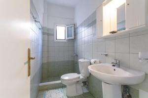 a bathroom with a toilet and a sink at Elsa House ground floor in Ágios Stéfanos