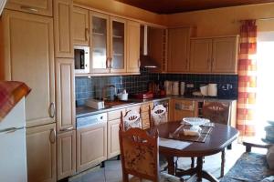 a kitchen with wooden cabinets and a table with chairs at Mama Sofias House Cozy 2 Bedroom Apartment in Kastríon
