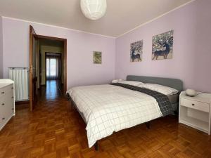 una camera con un letto e due quadri appesi al muro di Appartamento Ai Rododendri a Pray