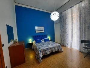 Mary's Sweet Home Napoli في نابولي: غرفة نوم زرقاء مع سرير وجدار ازرق