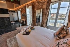 sypialnia z dużym białym łóżkiem i dużymi oknami w obiekcie Hospedium Hotel Barómetro de Camariñas w mieście Camariñas
