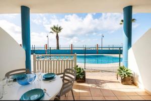 d'une terrasse avec une table et une vue sur la piscine. dans l'établissement Apartamento La Tortuga II Beach, à Tarifa