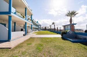 une rangée de bâtiments avec des palmiers et un trottoir dans l'établissement Apartamento La Tortuga II Beach, à Tarifa