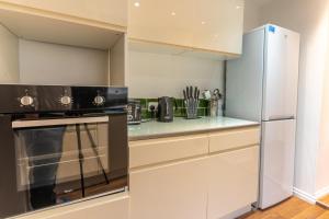 a kitchen with a stove and a refrigerator at Cheerful and modern 3 BDR for 7 in Liverpool