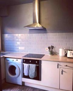 a kitchen with a stove and a washing machine at Chester/Handbridge sleeps 6 with BT Sports & Pac-man in Hough Green