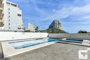 ein Schwimmbad mit einem Berg im Hintergrund in der Unterkunft Apartamento Bernia al Mar 8B - Grupo Turis in Calpe