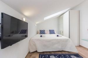 a bedroom with a large flat screen tv on the wall at Riva 2 in Krapanj